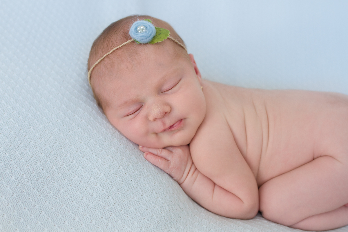 Ainda de bruços com a mão no queixinho, ela dá um sorrisinho pra gente!