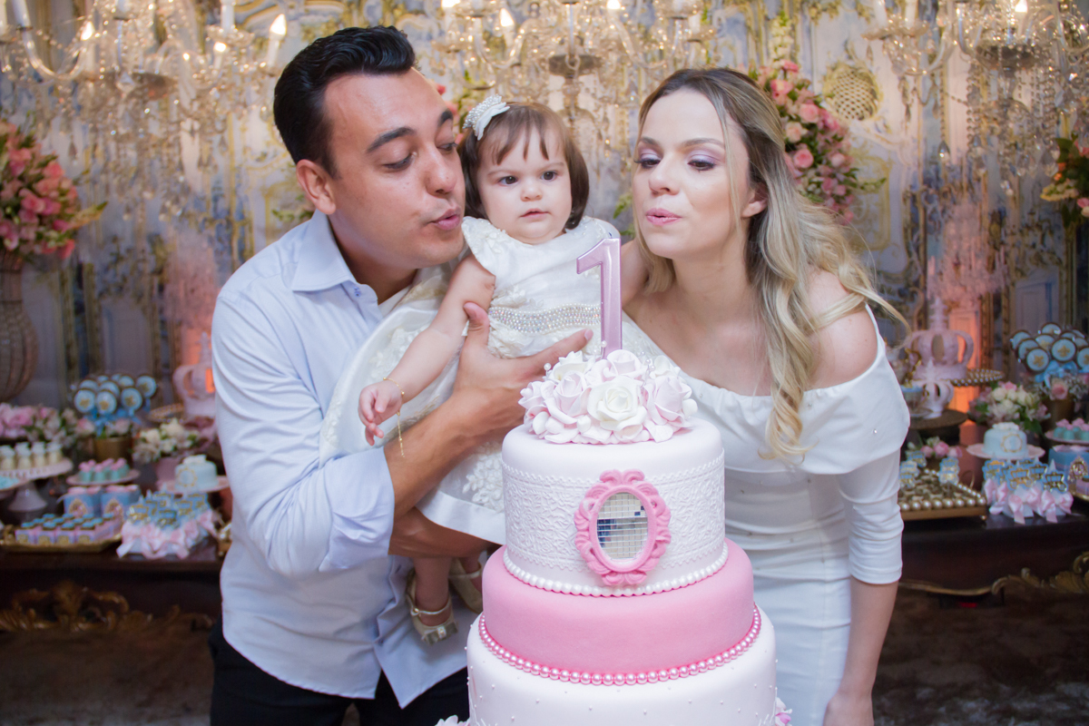 Papais assoprando a velinha de um aninho com a Maria