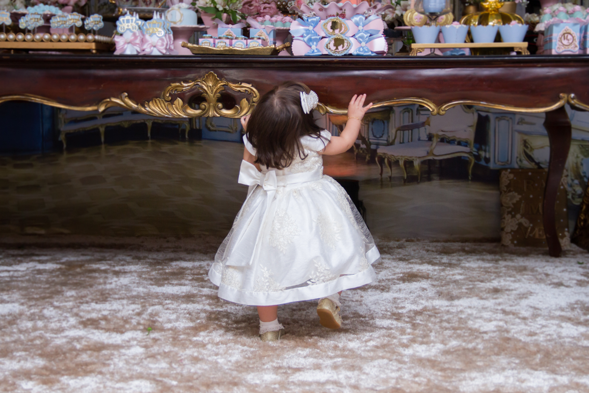 Maria tentando alcançar a mesa de doces