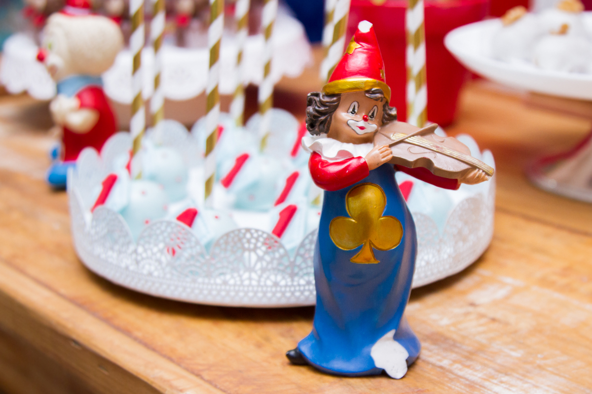 Close em um palhacinho tocando violino 