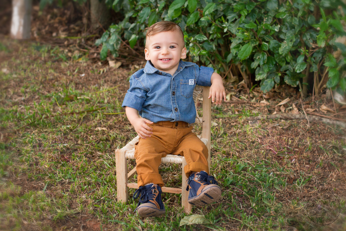 Ele está tão confortável na cadeirinha, que senta com um braço encostado na cadeira