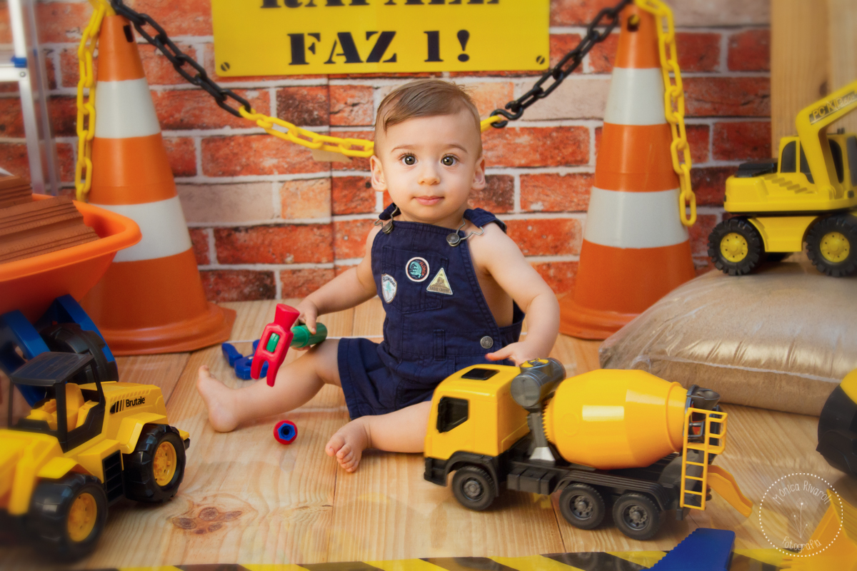 O Rafael olha para a foto enquanto brinca com o carrinho