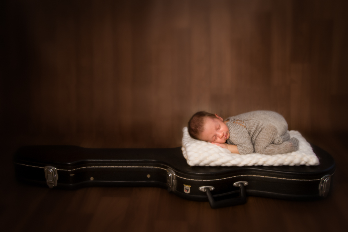 Como o papai do Dudu toca violão e guitarra, nesta foto, eles está deitado de bruços em cima do case da guitarra do papai