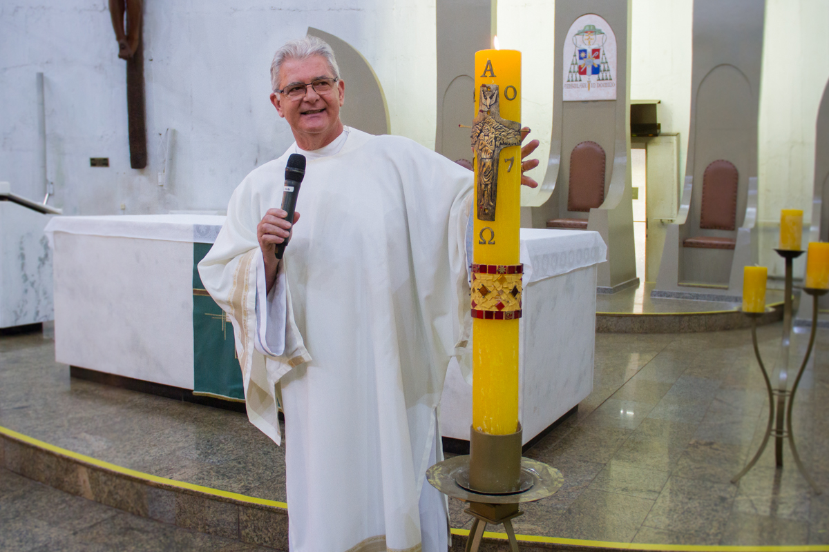 Foto do padre olhando para a vela 