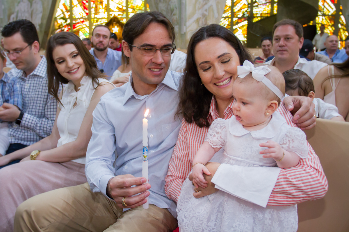 Fotinha da Isa olhando para a vela que está com o padrinho