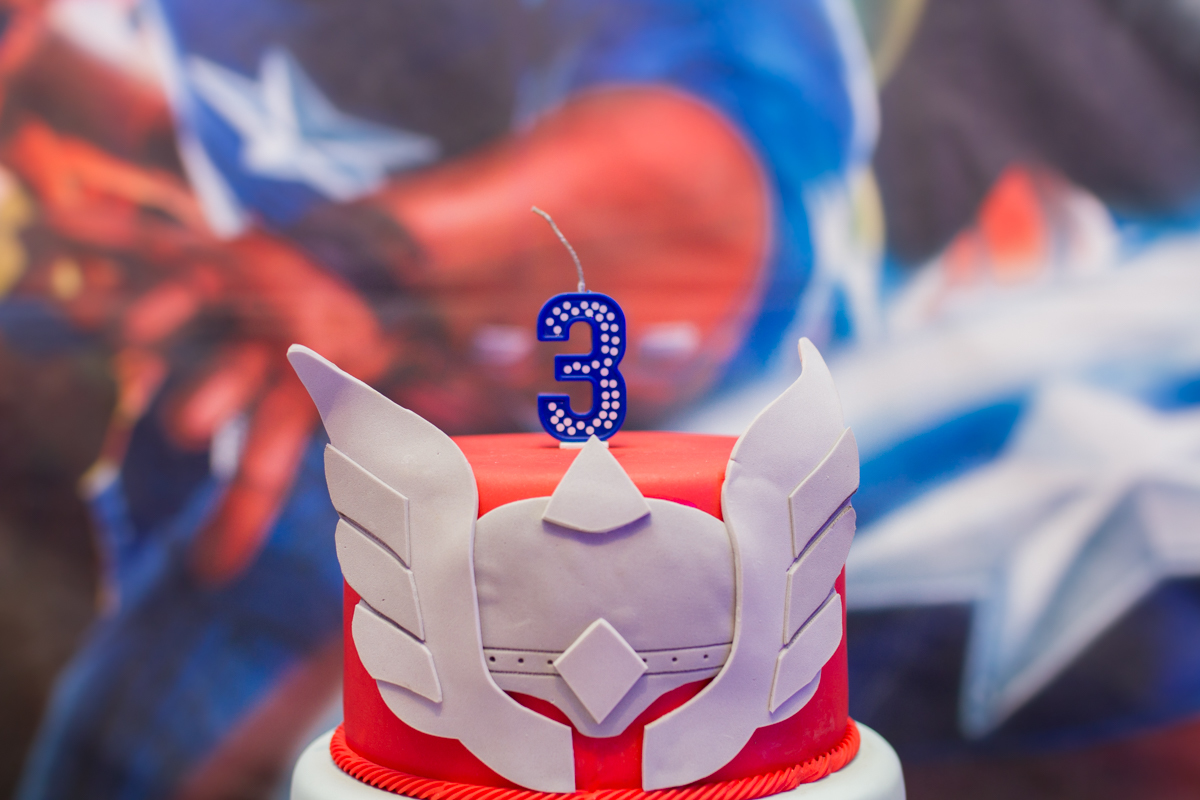 Close no topo do bolo com a vela de 3 anos do Léo