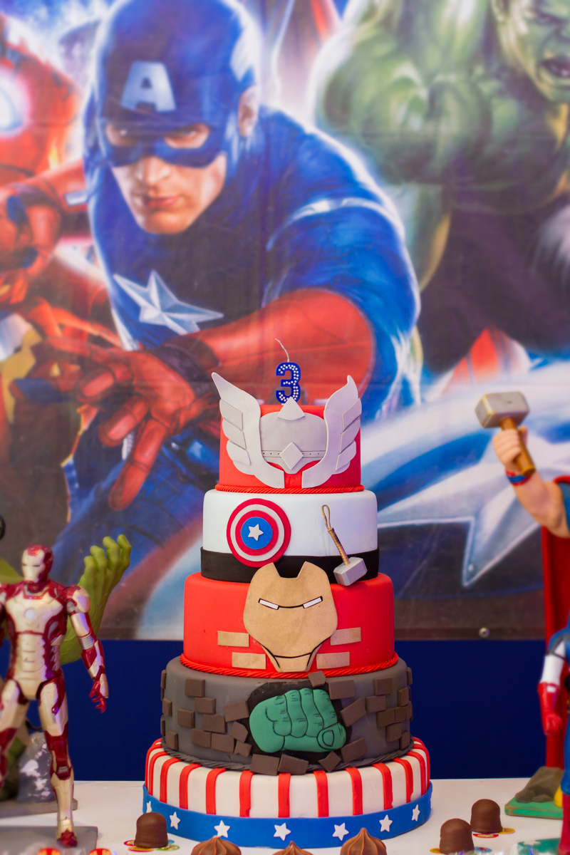 Close no bolo que está enfeitado com características de super heróis 