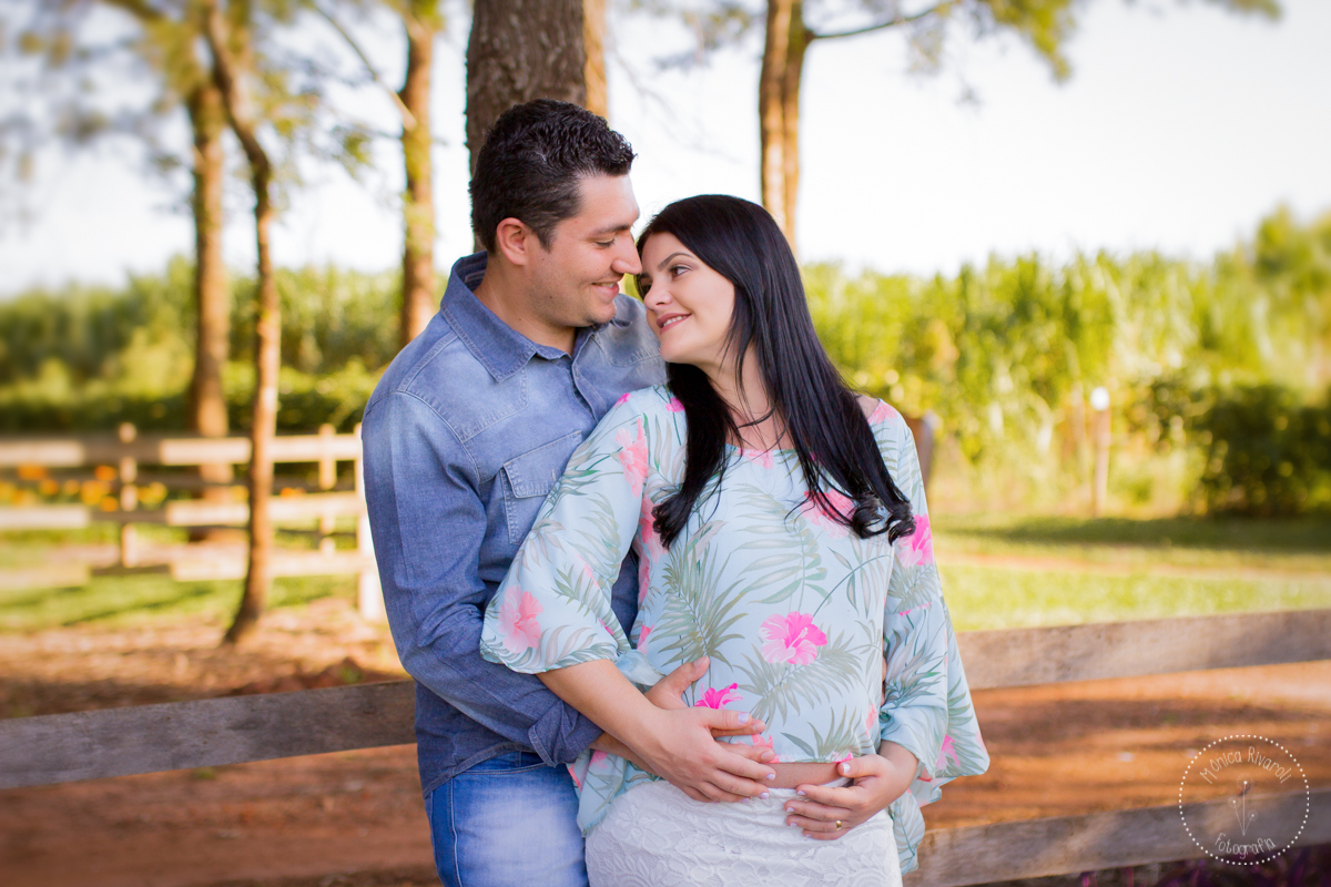 Os dois se olham com as mãos na barriga da gestante
