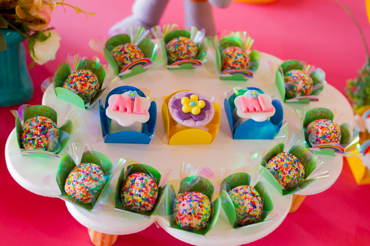 Aparador em forma de nuvem com docinhos coloridos e com as inicias da Malu em cima
