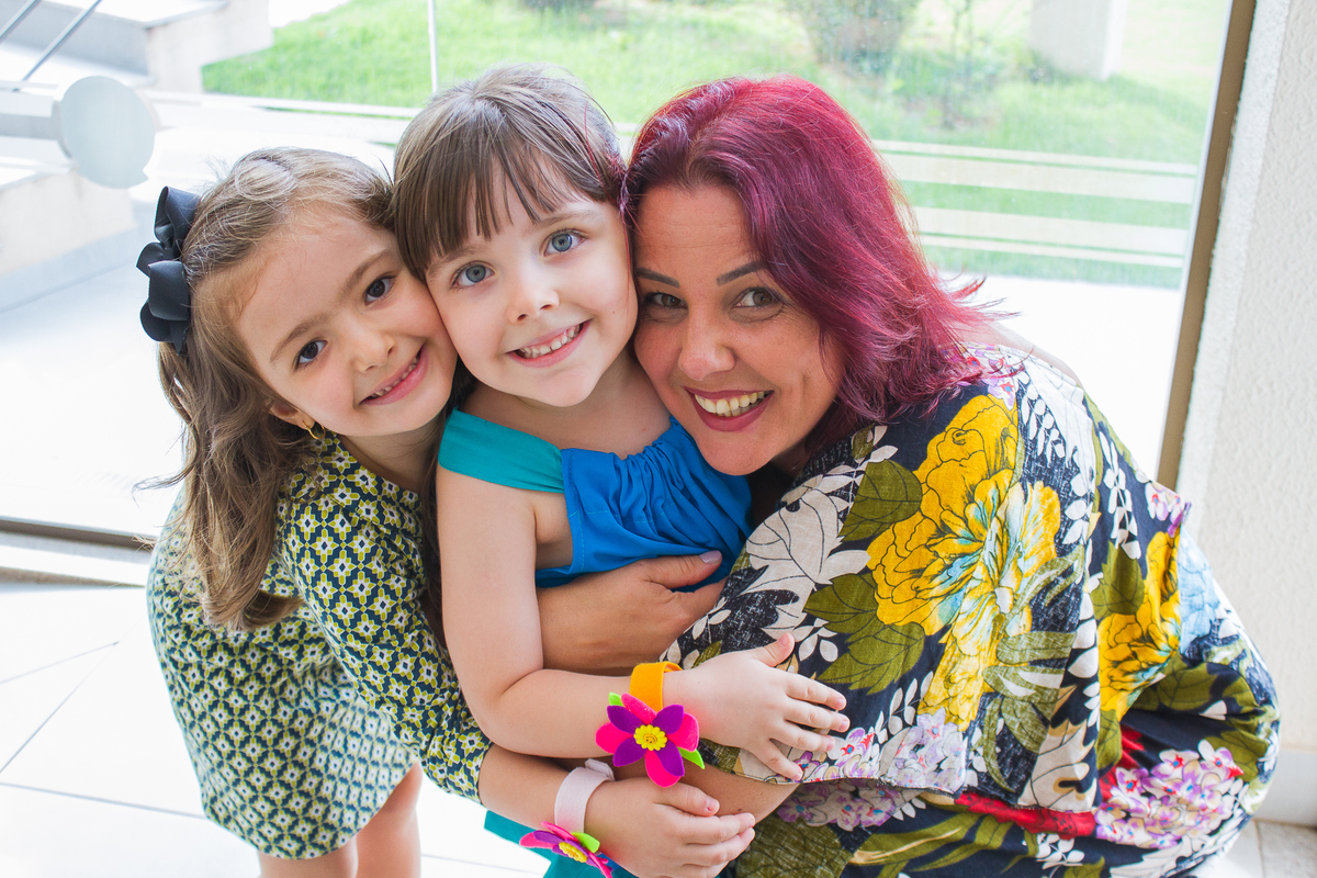 A Malu esta sendo abraçada por sua titia e sua amiguinha