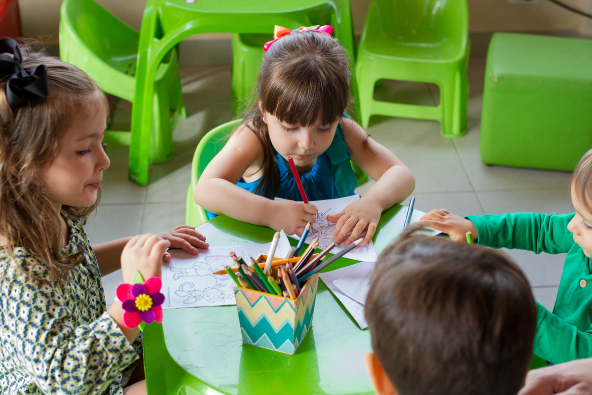 A Malu e seus amiguinhos estão na mesa pintando