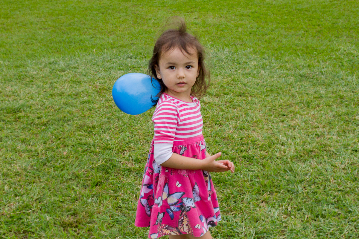 Close na amiguinha da Malu com uma bexiga brincando no campinho