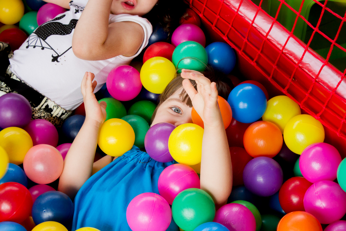 A Malu esta deitada na piscina de bolinhas e esta coberta de bolinhas