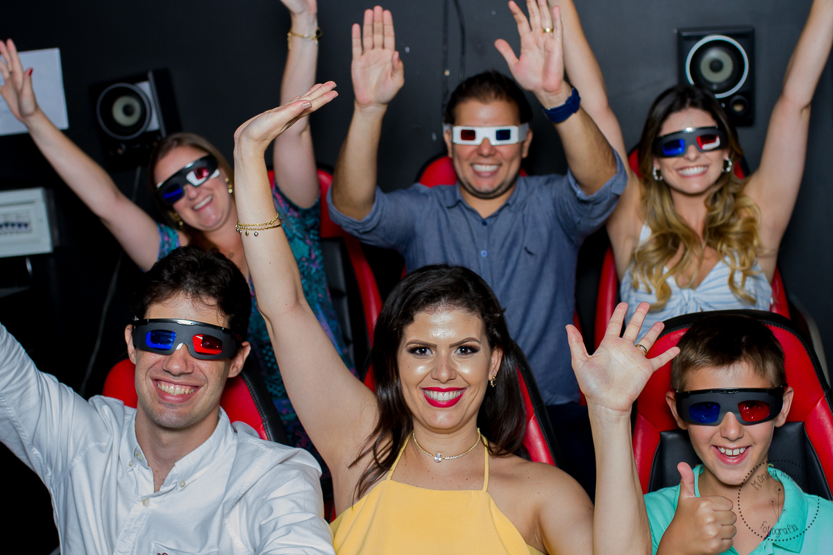 A mamãe e o papai, os titios e os convidados estão com os braços erguidos para tirar uma foto na boatinha 