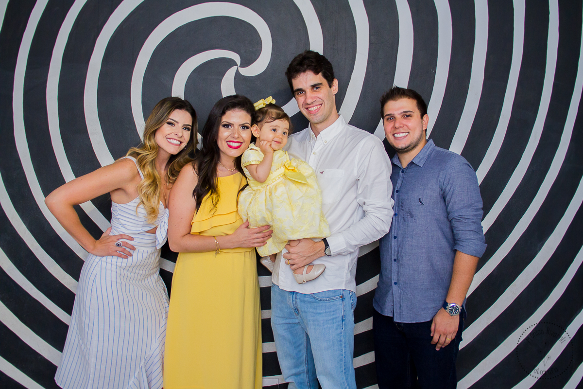 A Belle, a mamãe, o papai e os padrinhos estão tirando uma foto bem bonita na parede de espiral 