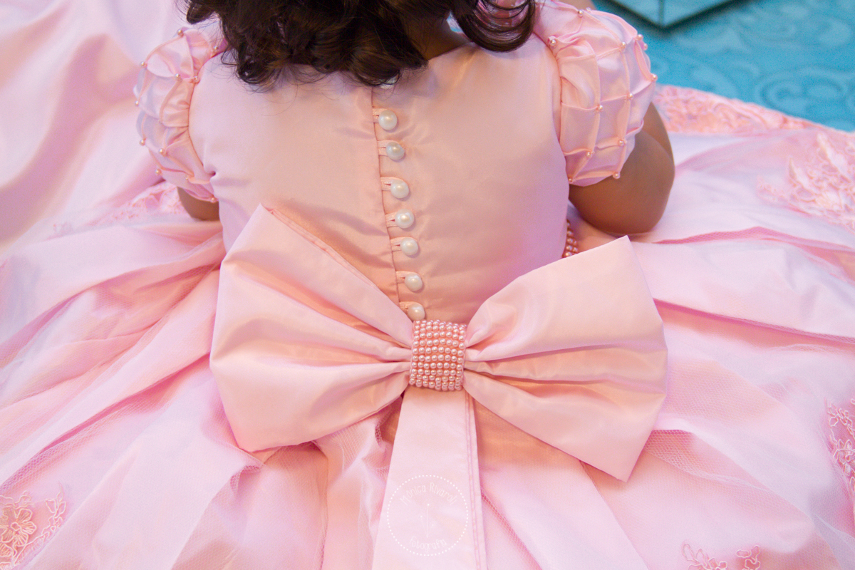 A foto mostra as costas do vestido lindo da Lívia, que tinha botões e um laço enorme 