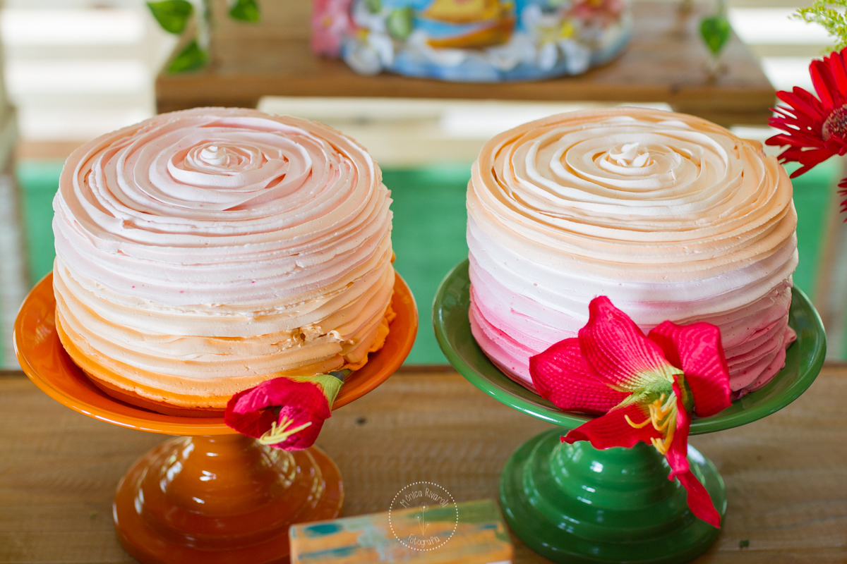 Foto dos dois bolos, um rosa e o outro laranja 