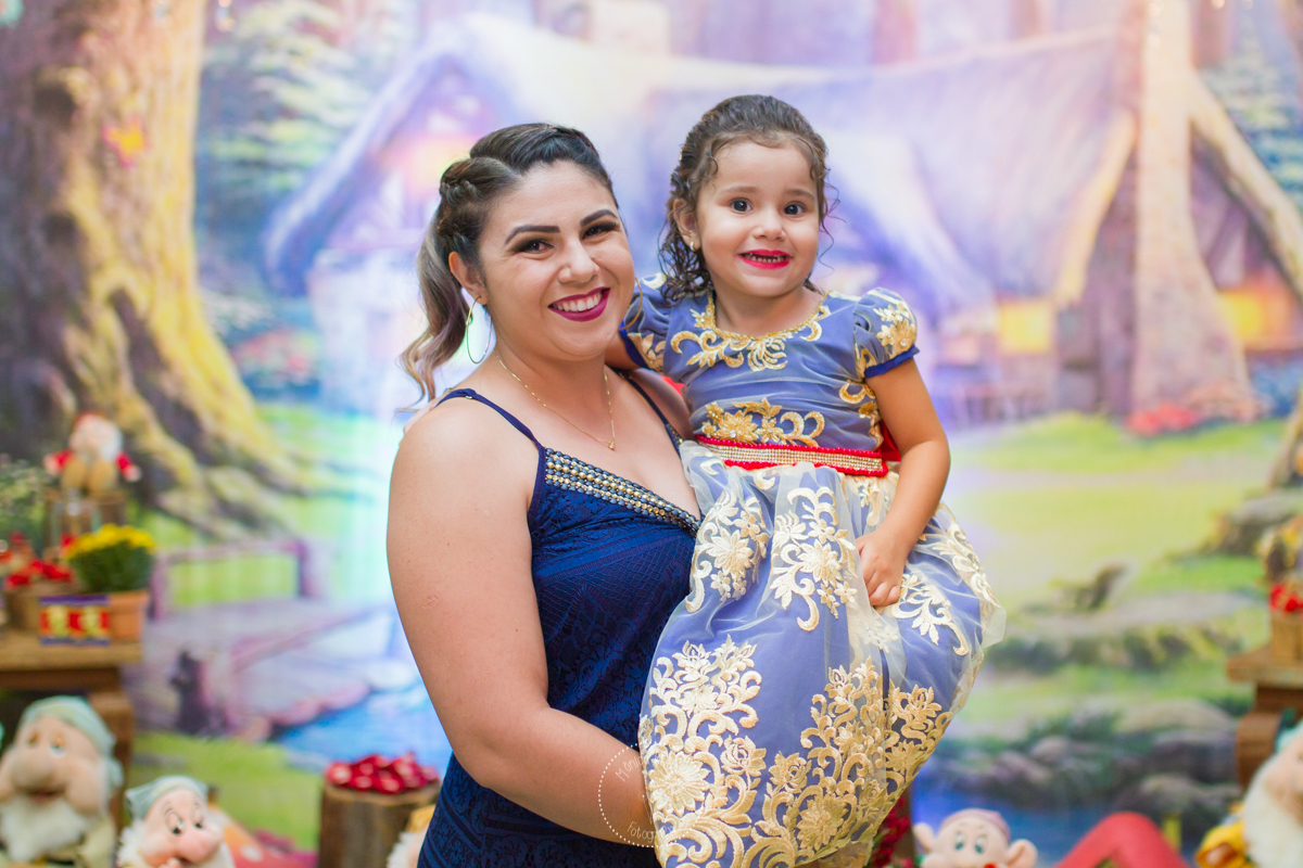 A Manu esta no colo da mamãe sorrindo para a foto