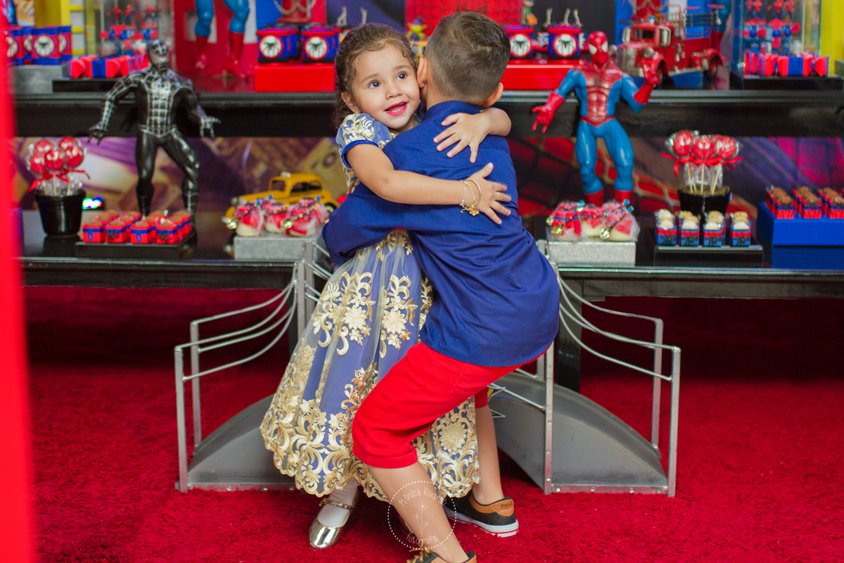 A Manu esta recebendo um abraço bem apertado do seu irmão 