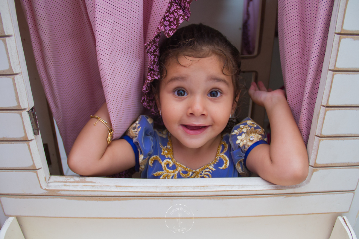 Manu na janela da casinha de bonecas