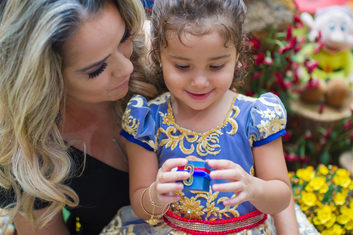 Manu no colo da tia Cris olhando o docinho