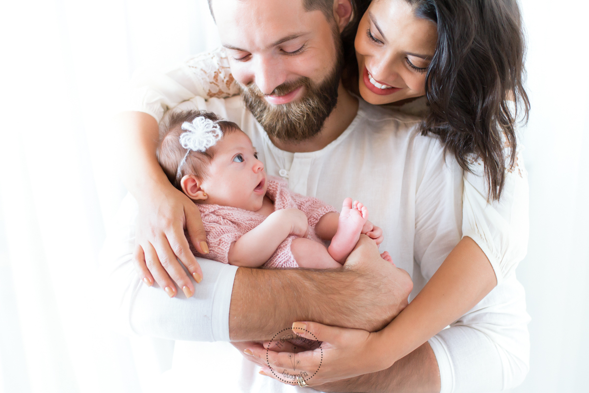 Nos braços do papai, que esta sendo abraçado pela mamãe, a Catarina esta olhando atentamente para eles
