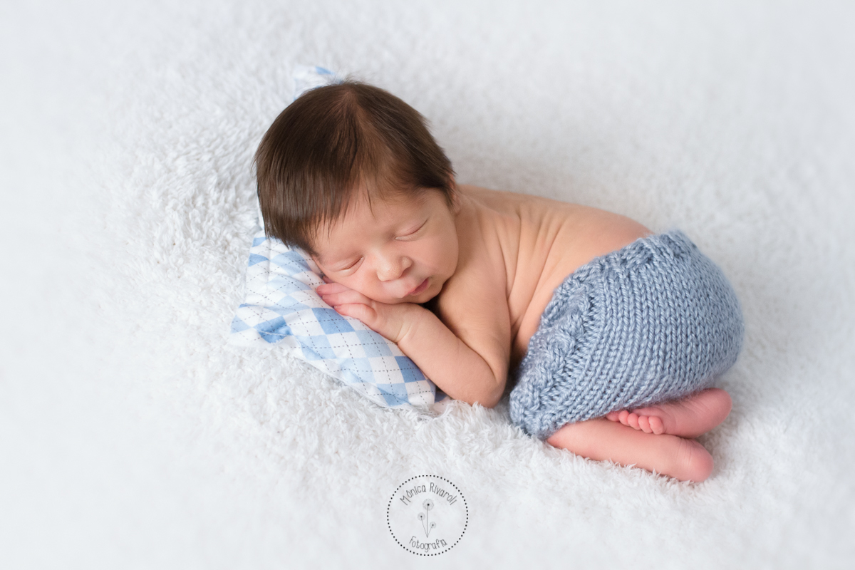 De bruços em uma mantinha branca, o Mateus dorme 