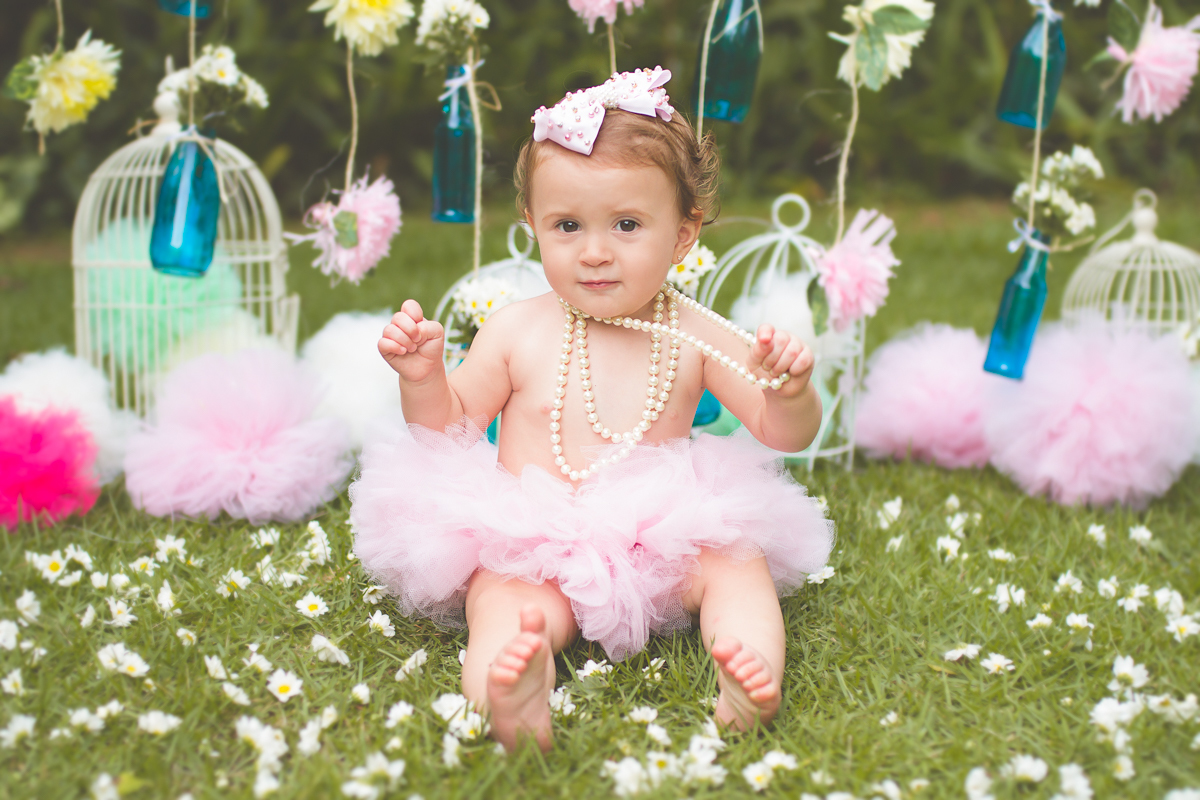 Ana Laura sentadinha em frente a decoração