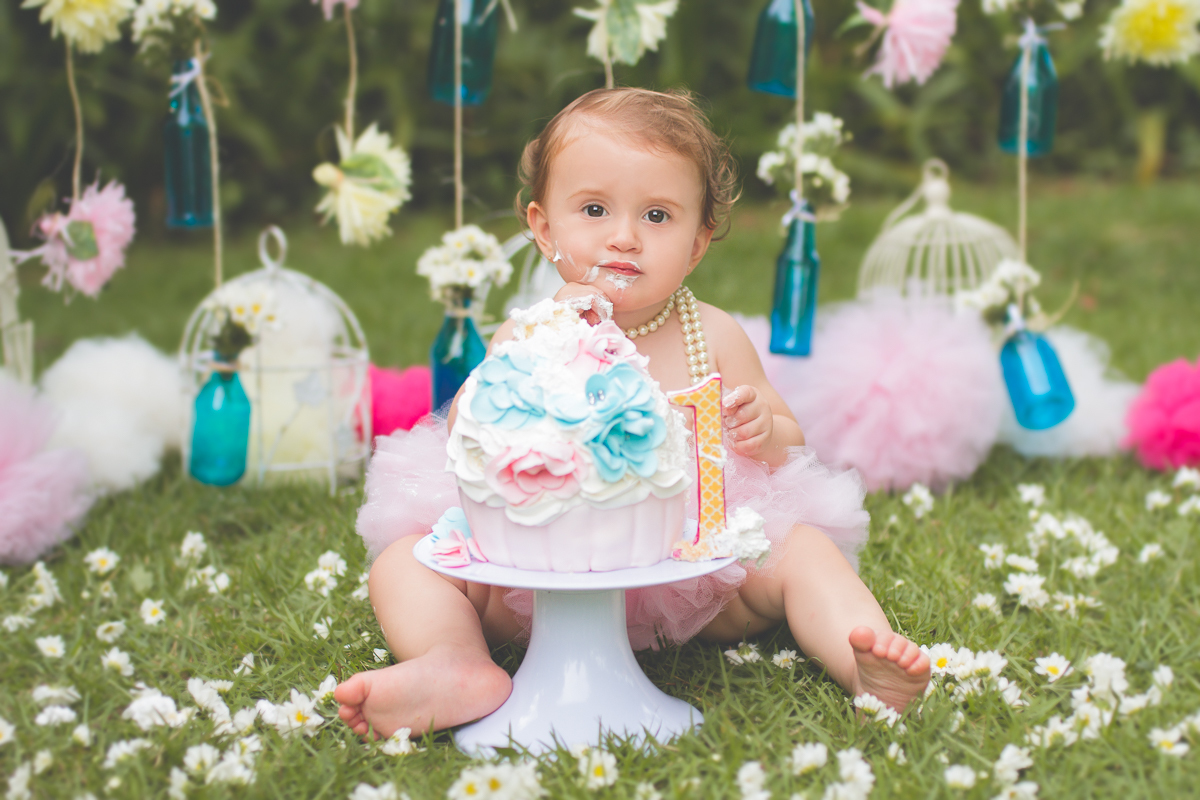 Ana olhando para a câmera enquanto mexe no bolo