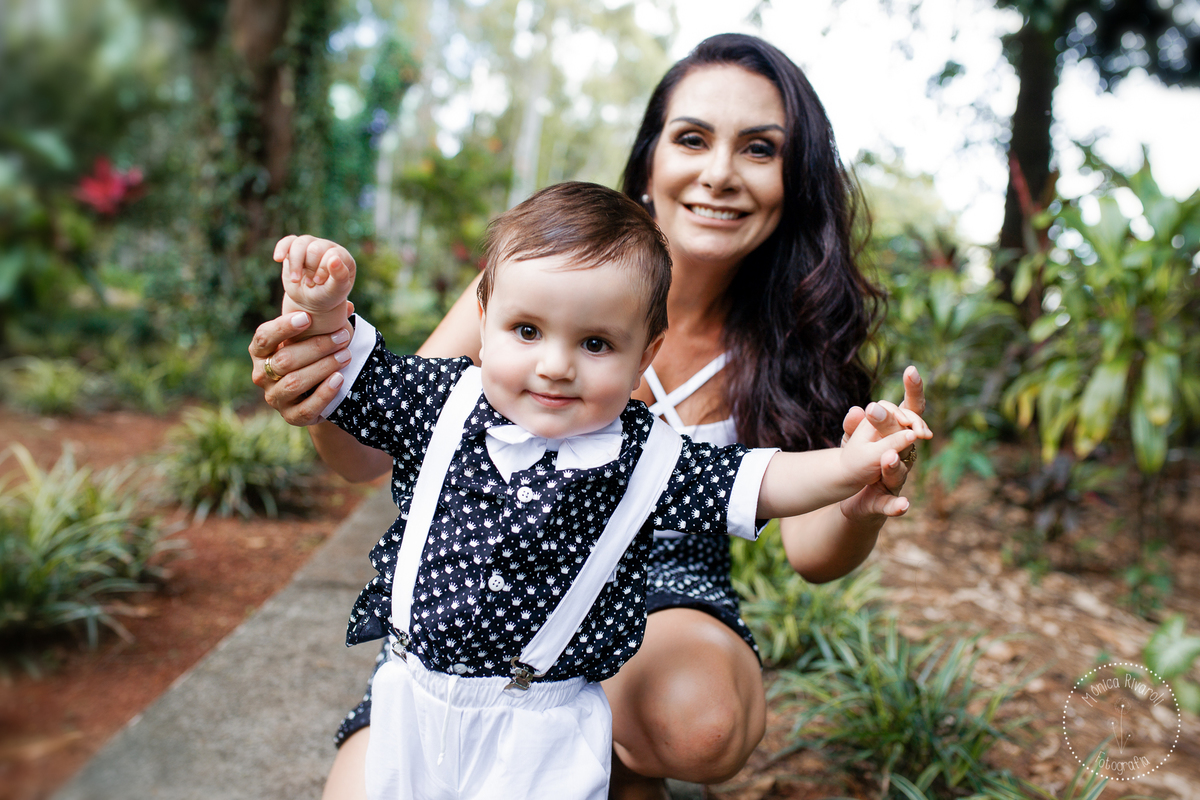 Mamãe atrás do Henrique o ajudando a andar e dando um sorriso lindo para a foto