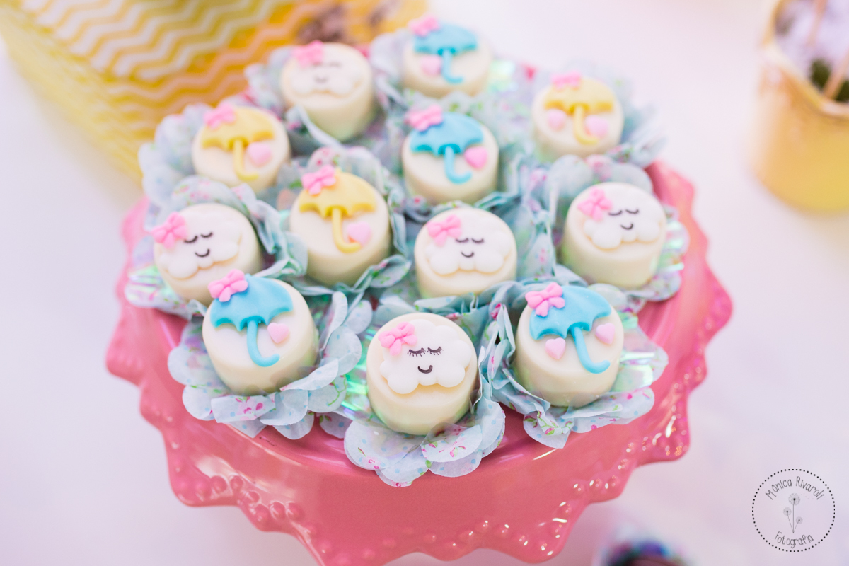 Aparador rosa com docinho decorado com nuvens e guarda-chuvas 