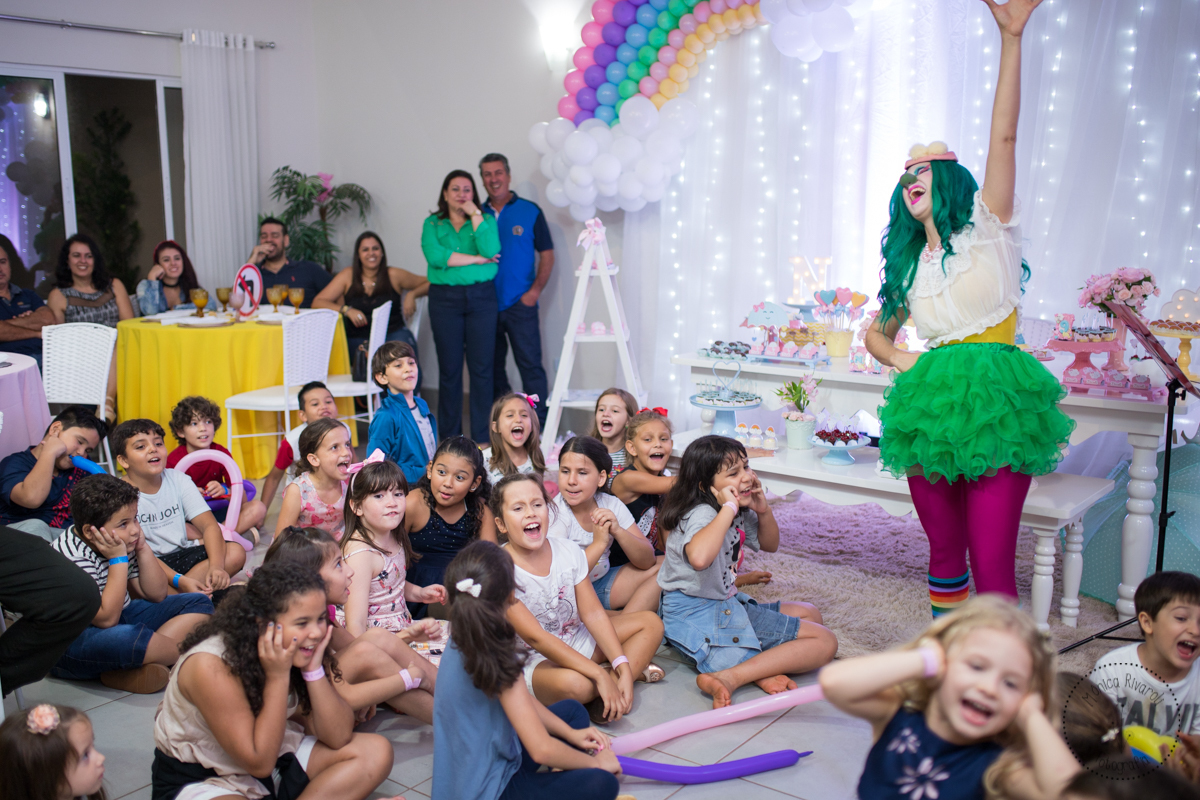 Crianças sentadas no chão perto da mesa de doces 