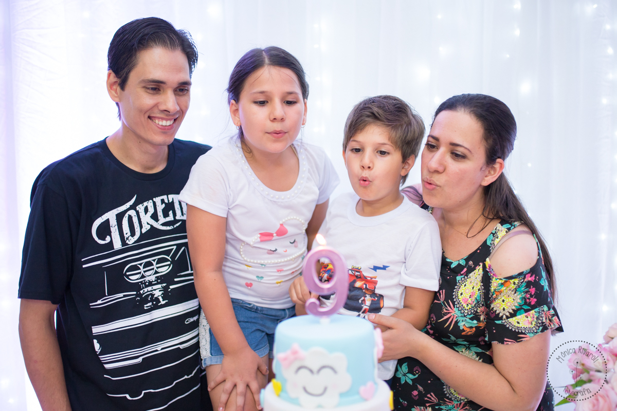 A família se junta para assoprar a velinha 