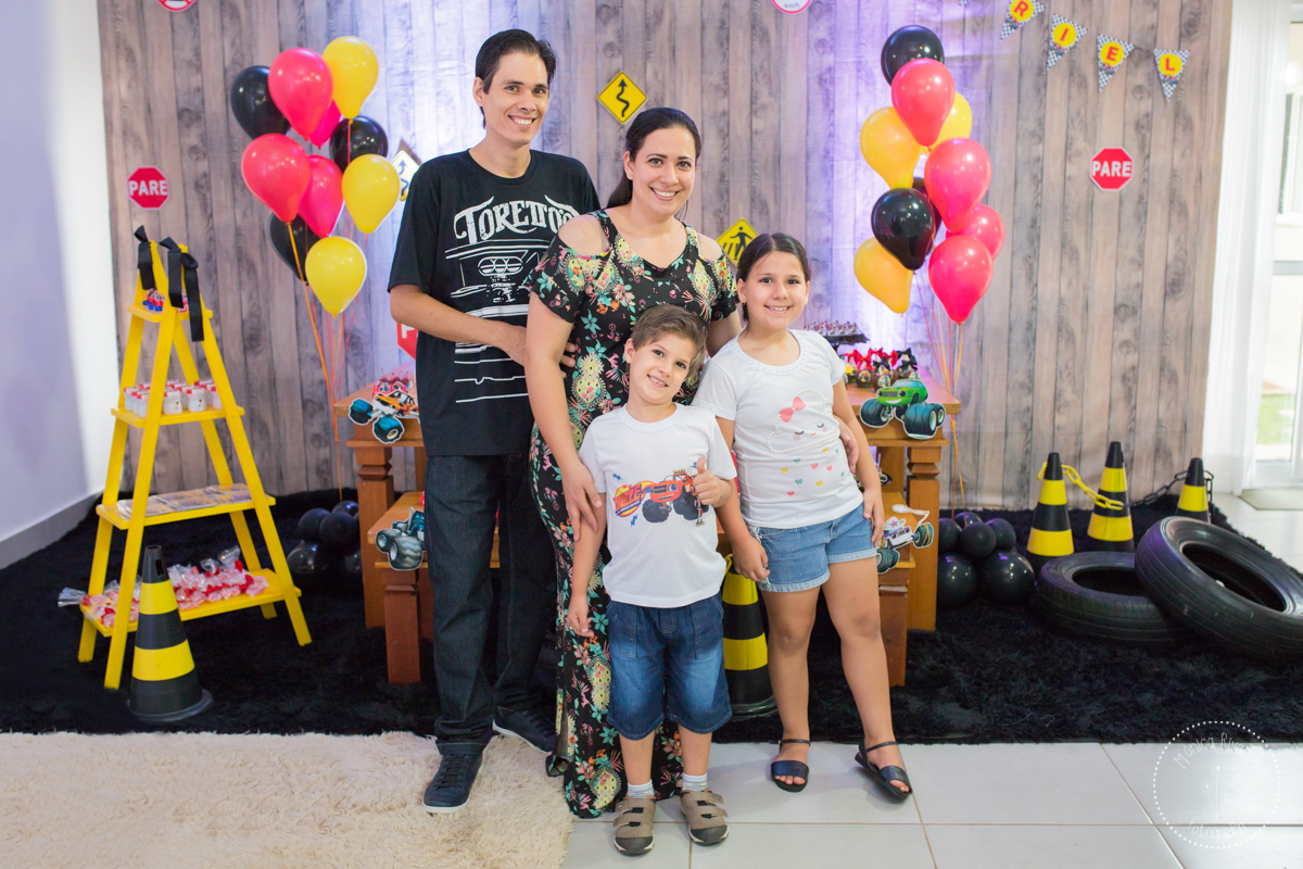 Papai, mamãe, Gabriel e Nicoli posando para uma foto em frente da decoração