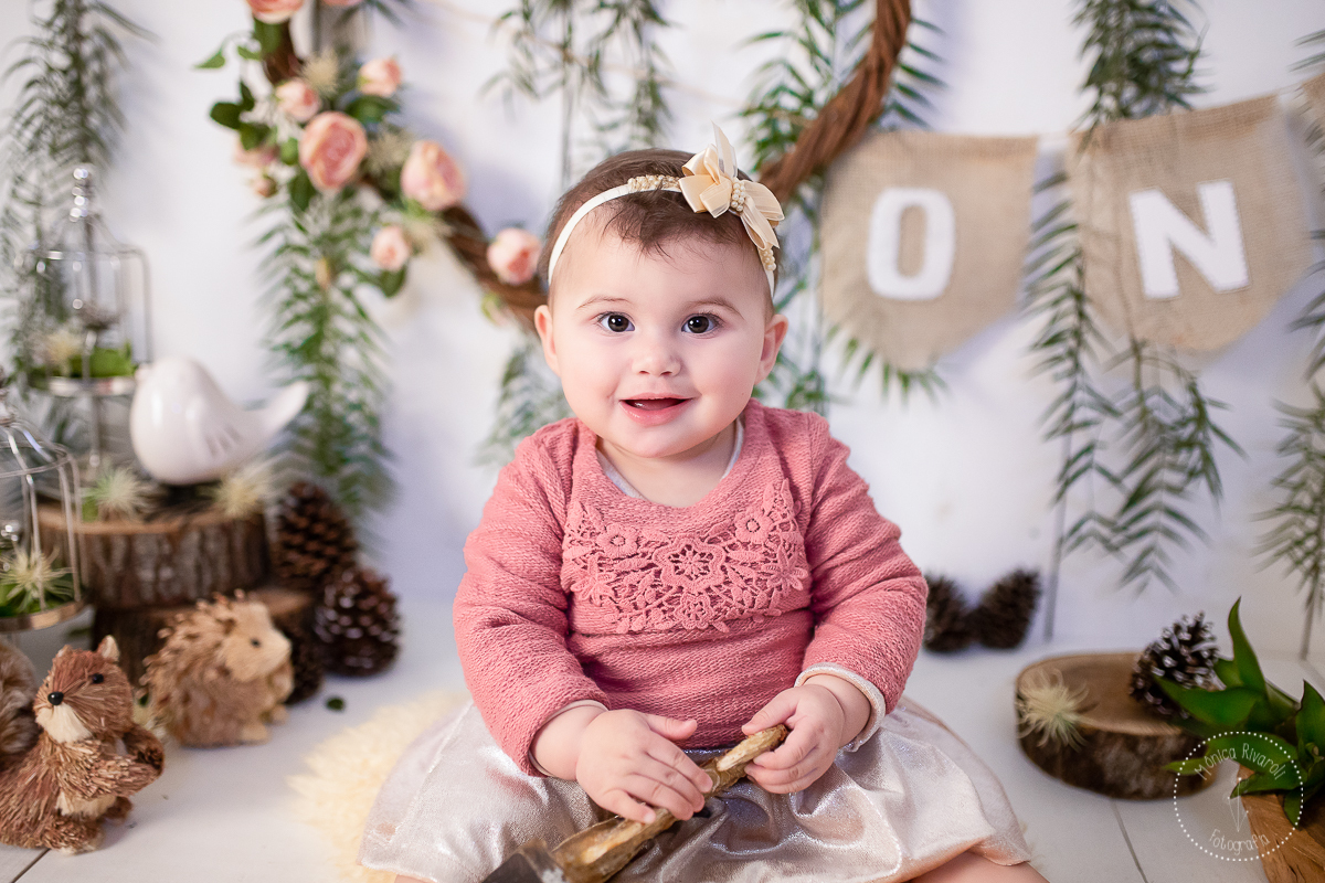 uma fotografia mais pertinho do rostinho da neném e ela sorri segurando um esquilo presente no cenário
