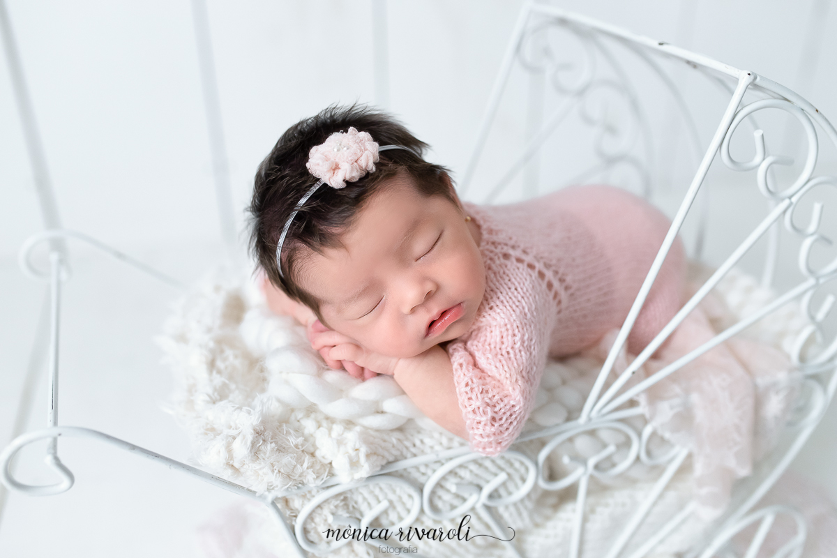 Um close do rostinho da bebê deitada no carrinho