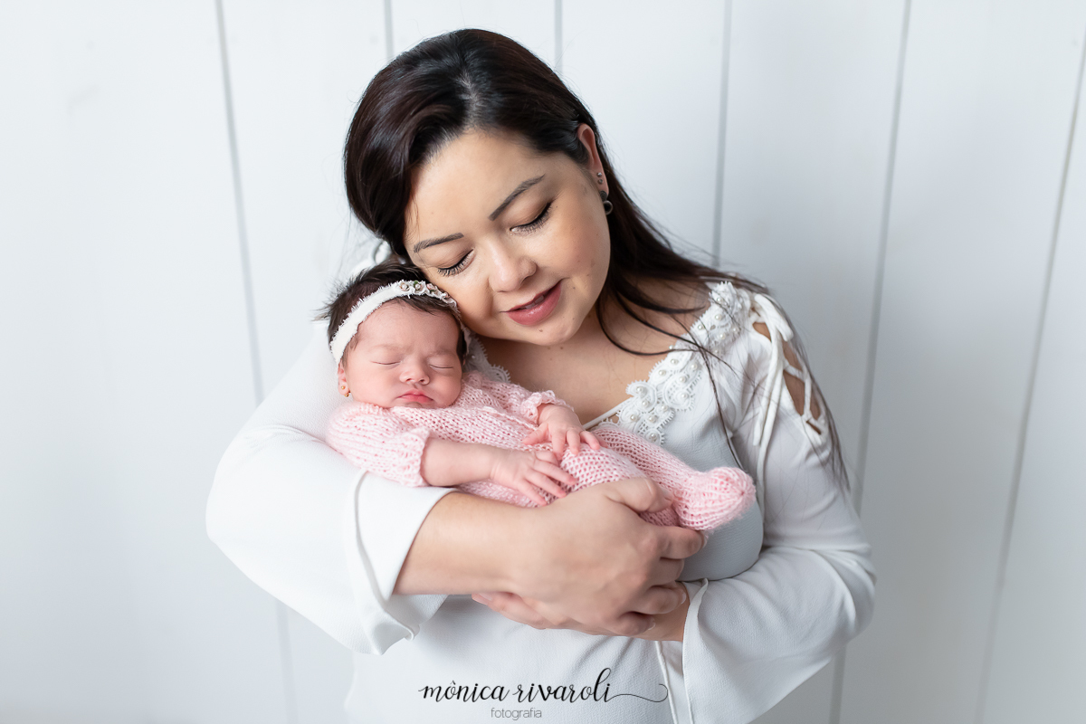 Foto com a mamãe com a cabeça bem próxima o neném. a Mãe está com os olhos fechados e sorri