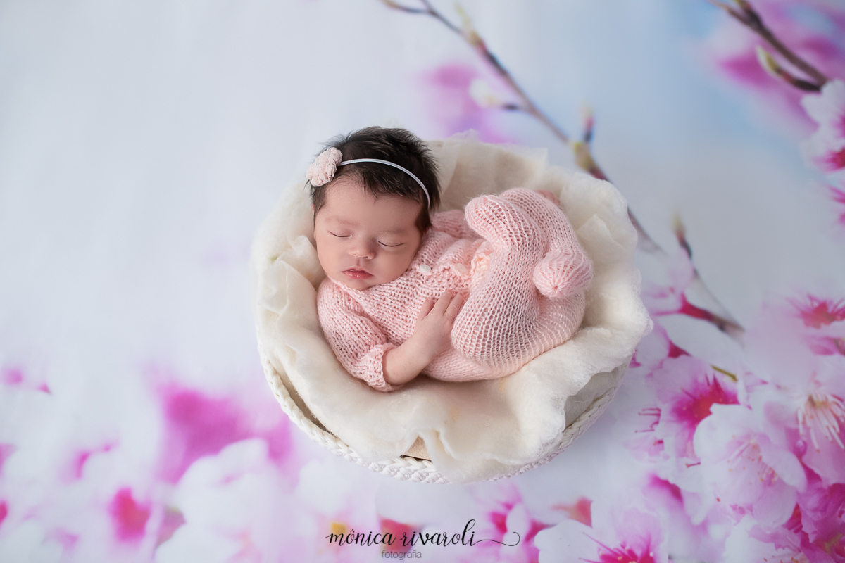 Uma foto mais próxima, em que a fotógrafa de newborn de Maringá/PR, faz um close da bebê no fundo de cerejeira