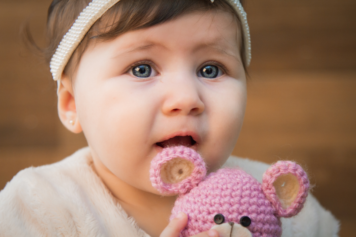 Mariah está segurando um urso com o foco em seus olhos