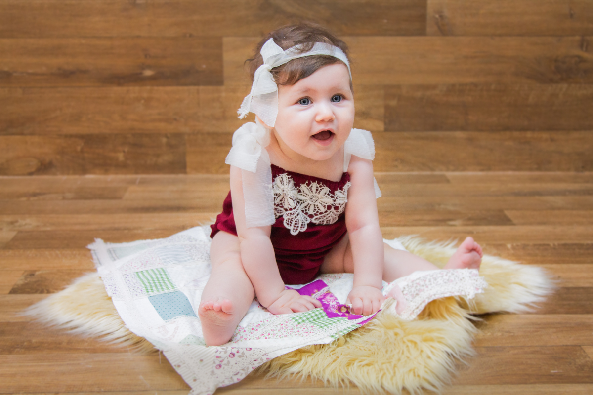 Em cima de um pêlo fofinho, a Mariah sorri e segura os pezinhos