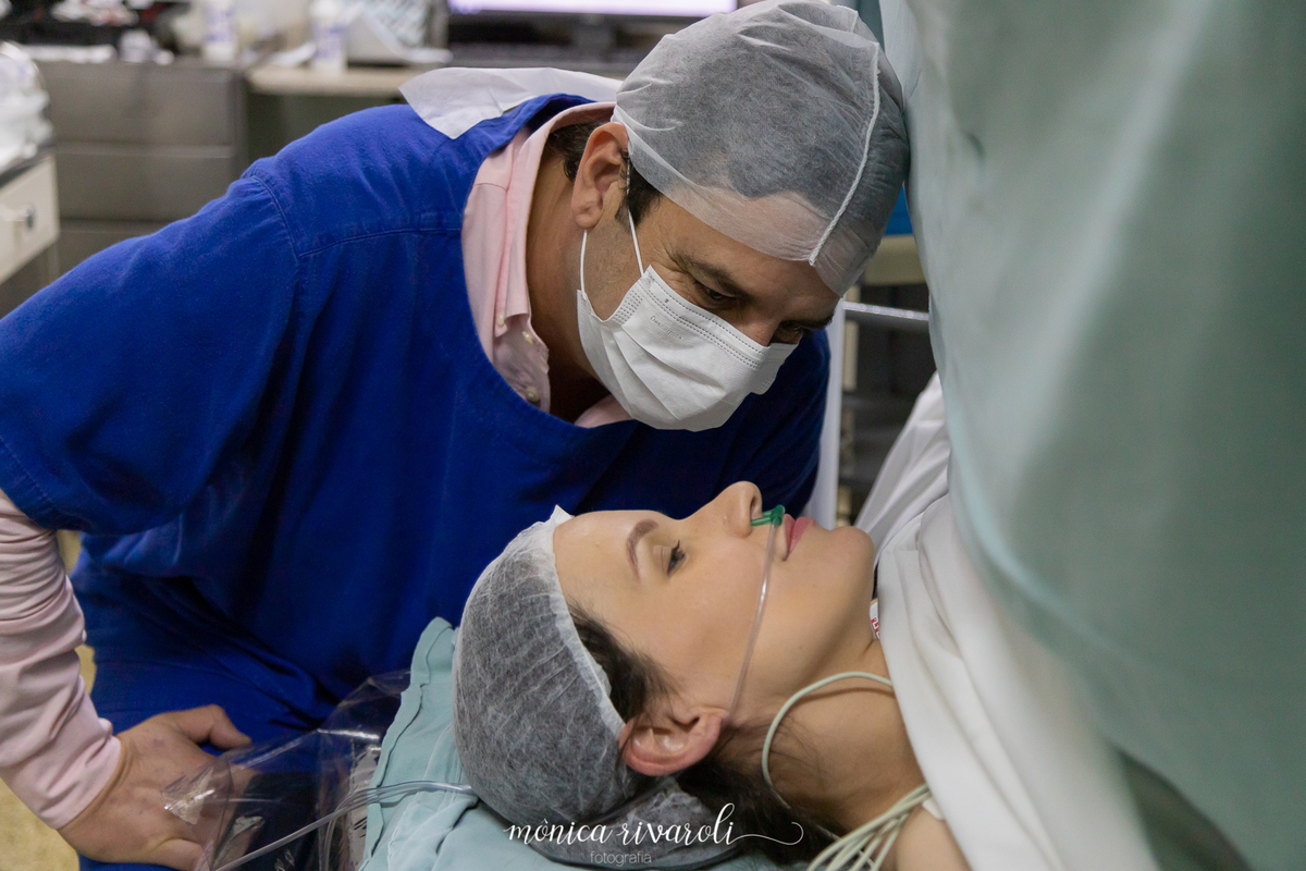 O papai Olha profundamento nos olhos da mamãe para saber se esta tudo bem.Fotografo de parto Mônica Rivaroli fotografia em Maringá. Tentantes, infertilidade, trombofilia endometriose. 