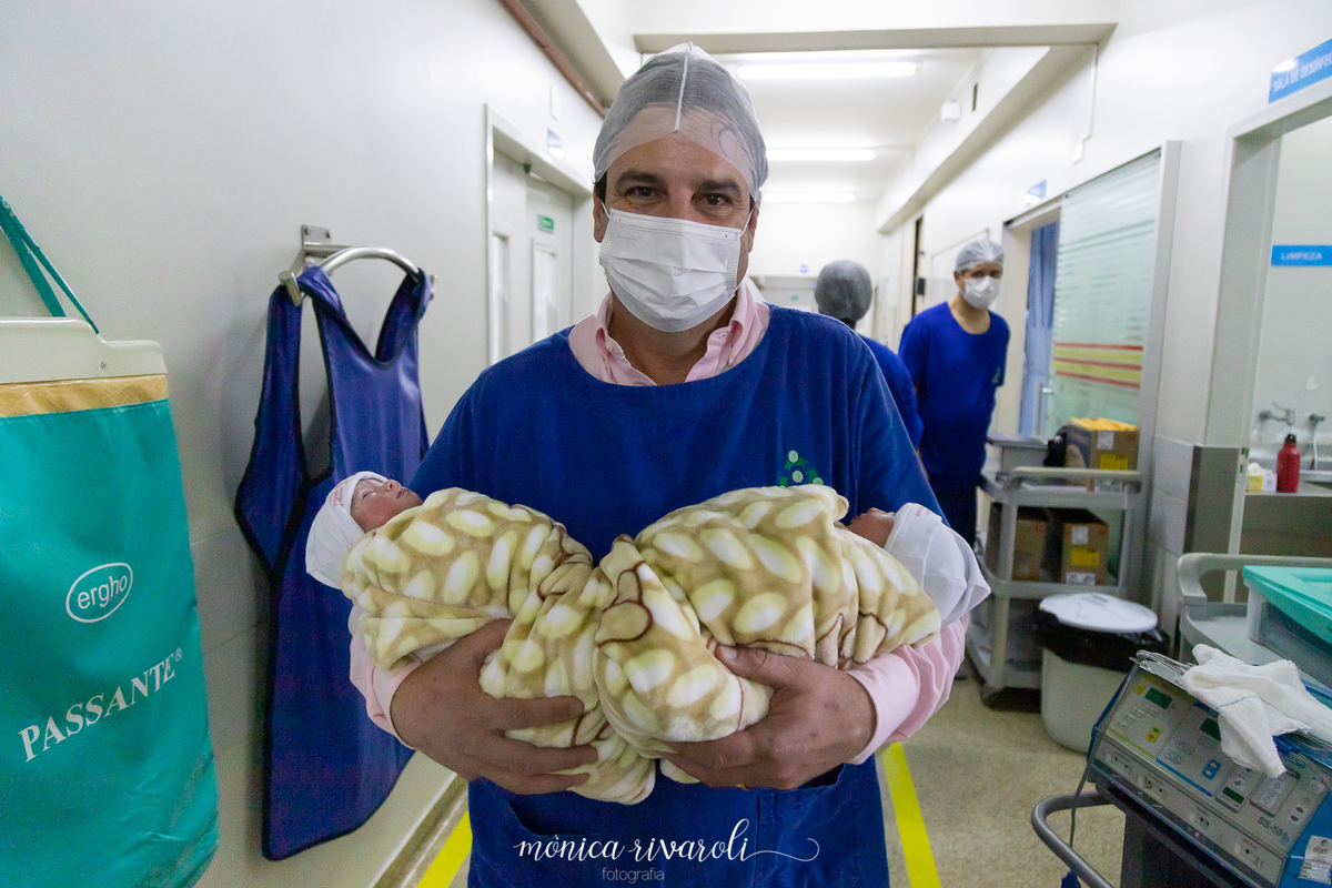 Idelber leva as Anas para o bercário. Fotografo de parto Mônica Rivaroli .fotografia em Maringá. Tentantes, infertilidade, trombofilia endometriose. Ele segura uma em cada braço.
