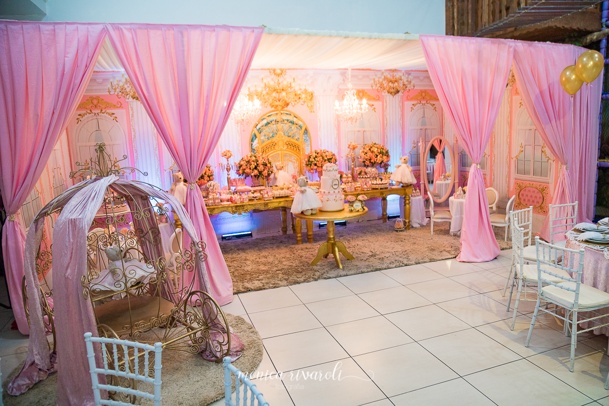 No cenário principal havia uma carruagem dourada. O painel remete a um palácio com lustres rosa, mesas douradas e um pergolado revestido de tecido. Fotografas de aniversário Monica Rivaroli Fotografia. Buffet Jungle Kids em Maringá.