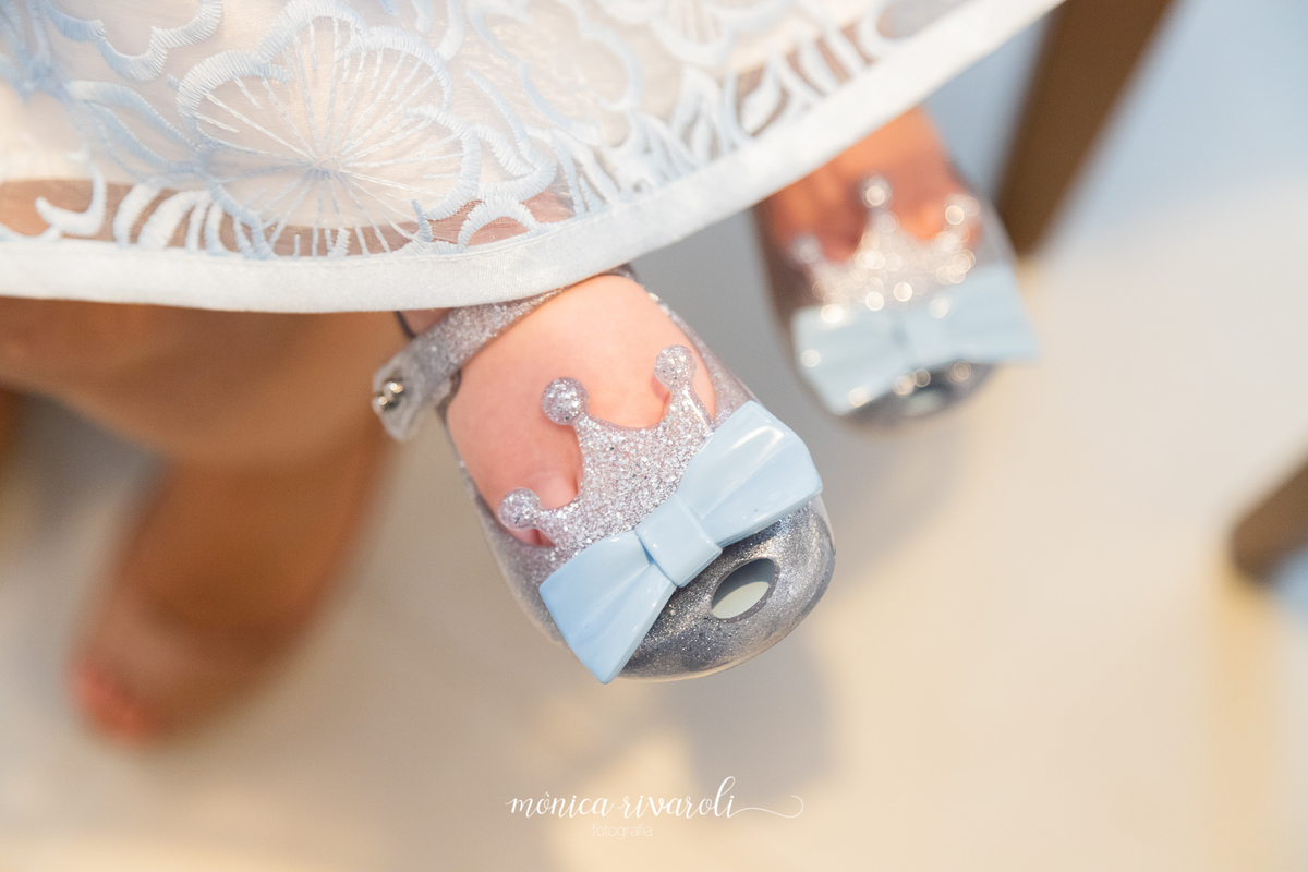 Close do sapatinho da Mariah. É uma sapatilha de glitter com uma coroa e um laço azul