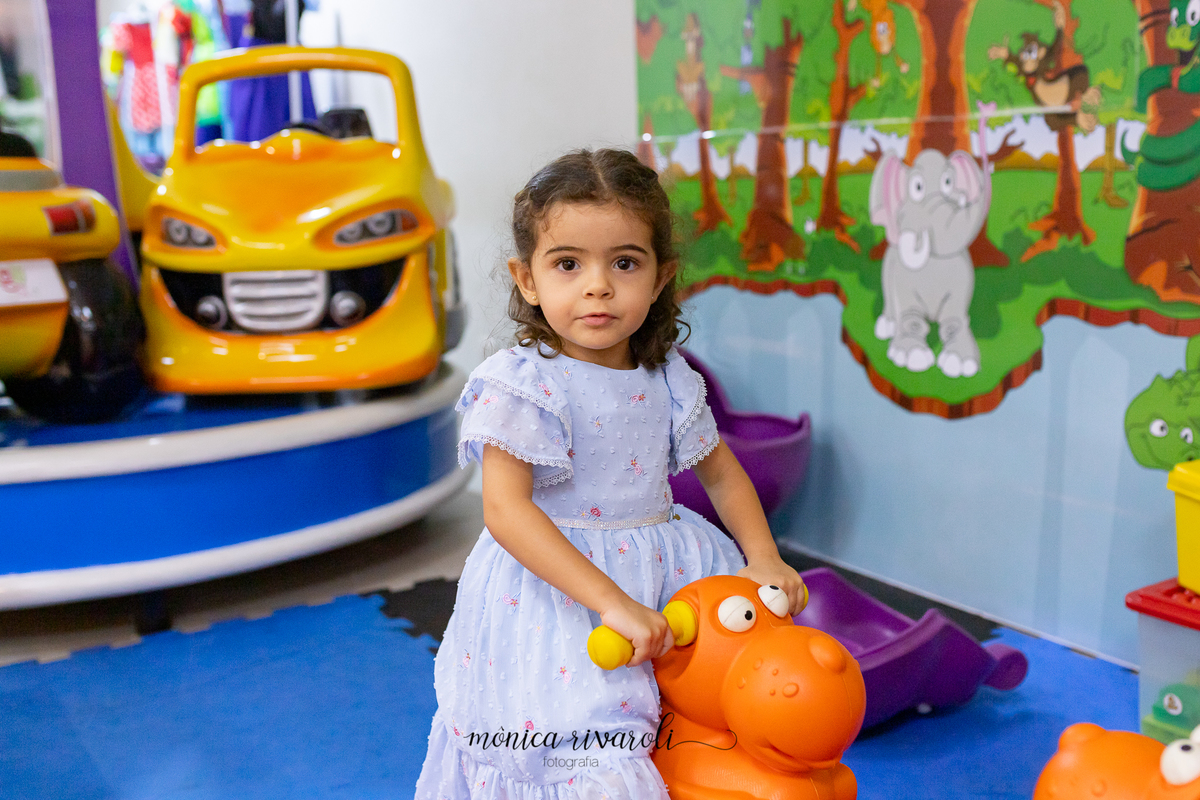 A BEATRIZ SE DIVERTIU MUITO COM OS BRINQUEDOS DO BUFFET ELA ESTÁ EM UM CAVALINHO INFLÁVEL.