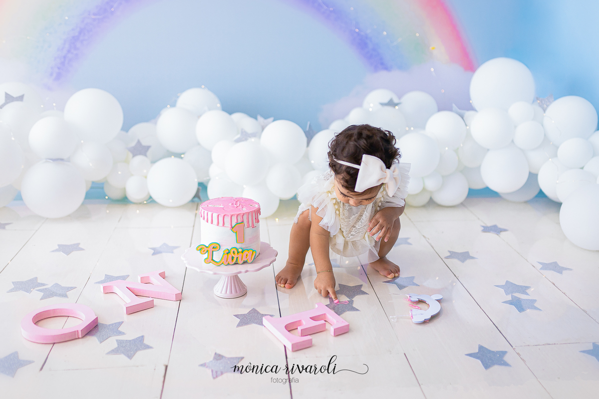 A LIVIA ESTA BRINCANDO COM AS ESTRELAS PRATEADAS NO CHÃO.