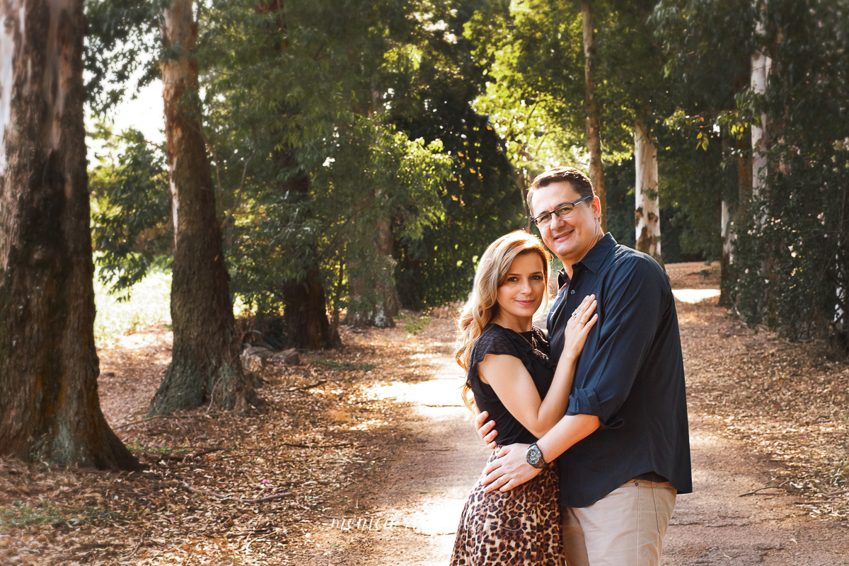 Na mesma estrada de chão, mas agora apenas o pai e a mãe estão na fotografia. Eles se abraçam, a mãe com a mão sobre o peito do pai, e o pai a envolve com uma mão na cintura e outra nas costas. Os dois olham para a câmera e sorriem. 