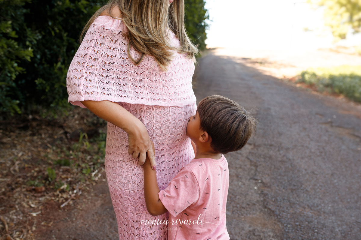 Ainda no mesmo cenário, na foto aparece apenas a barriga da mãe grávida e o irmão mais velho. Ele está beijando a irmã que está dentro da barriga, também está segurando as mãos da mãe
Ensaio Gestante
Fotografado por Mônicas Fotografia em Maringá-PR