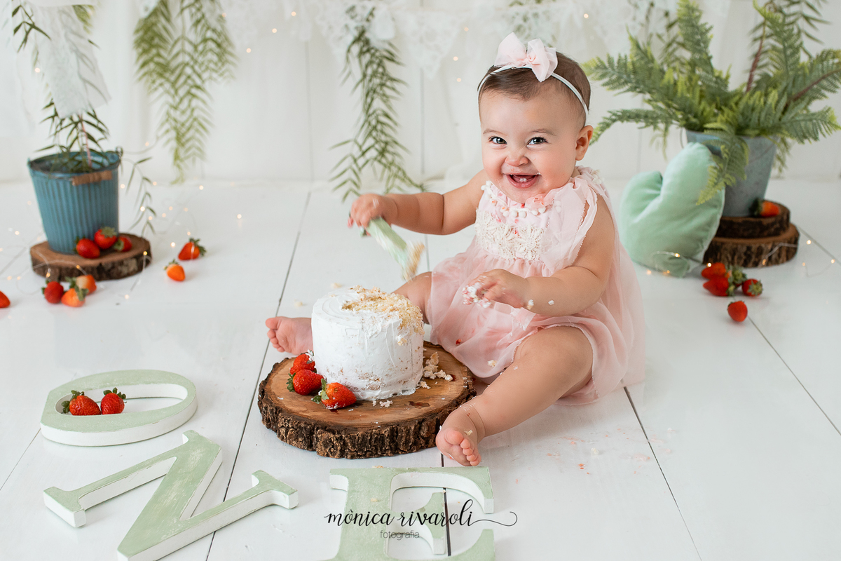 No cenário de Smash, a bebê está com as mãos lambuzadas de bolo e rindo.
Ensaio Smash The Cake
Fotografado por Mônicas Fotografia em Maringá-PR