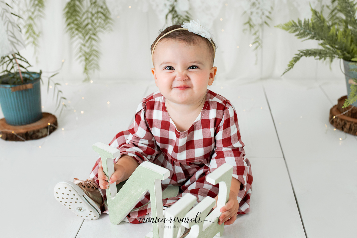 No cenário de Smash, a bebê está com uma roupa xadrez vermelha. Ela está segurando as letras da palavra 